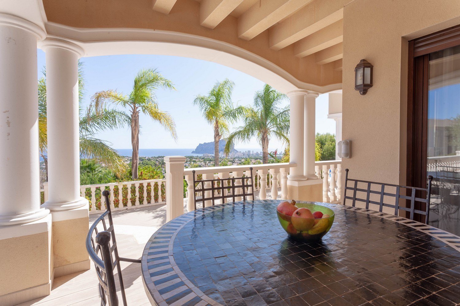 Covered terrace with mosaic table and panoramic sea views.