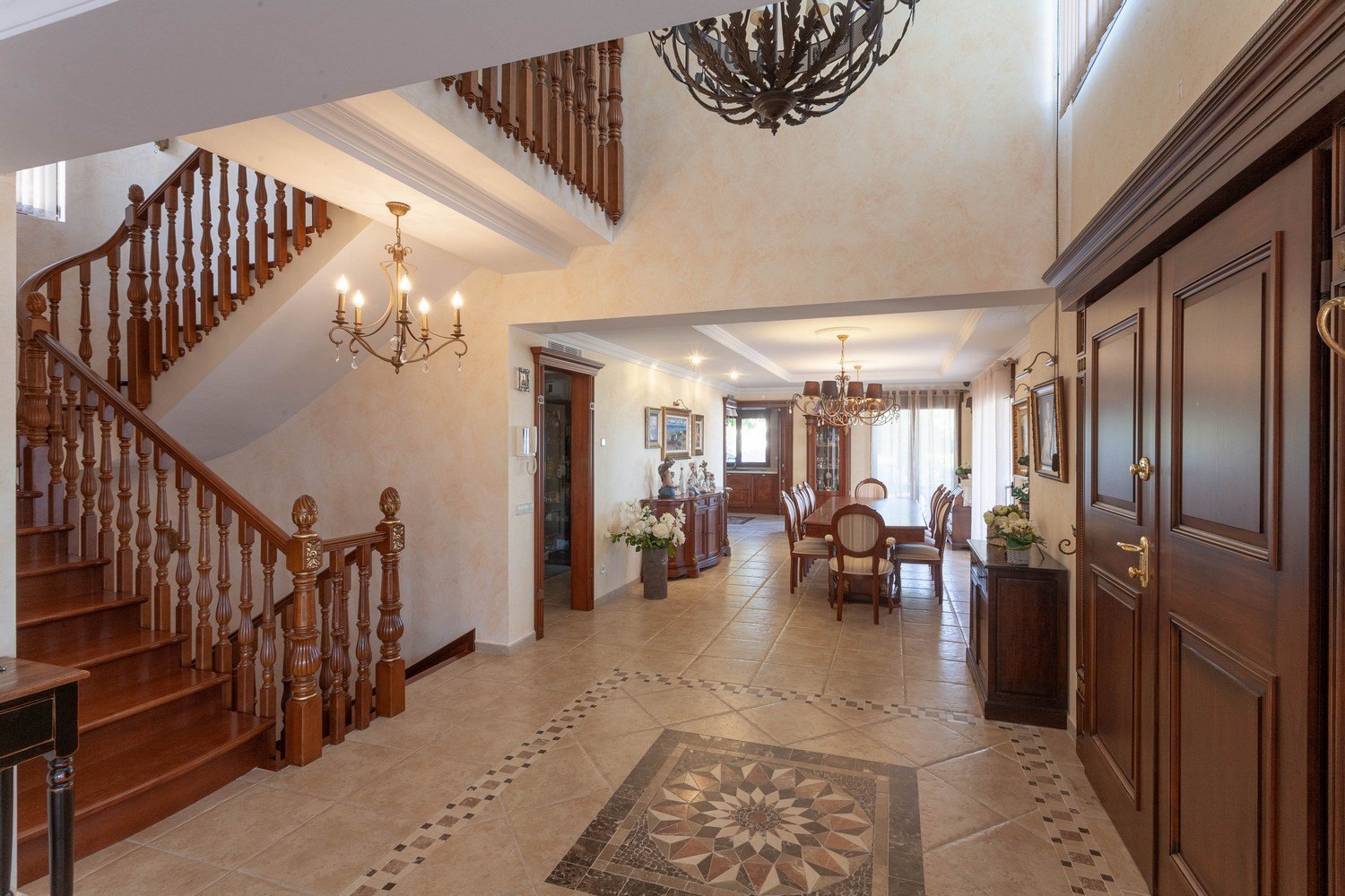 Entry foyer featuring a wooden staircase, decorative tile flooring, and access to the dining room.