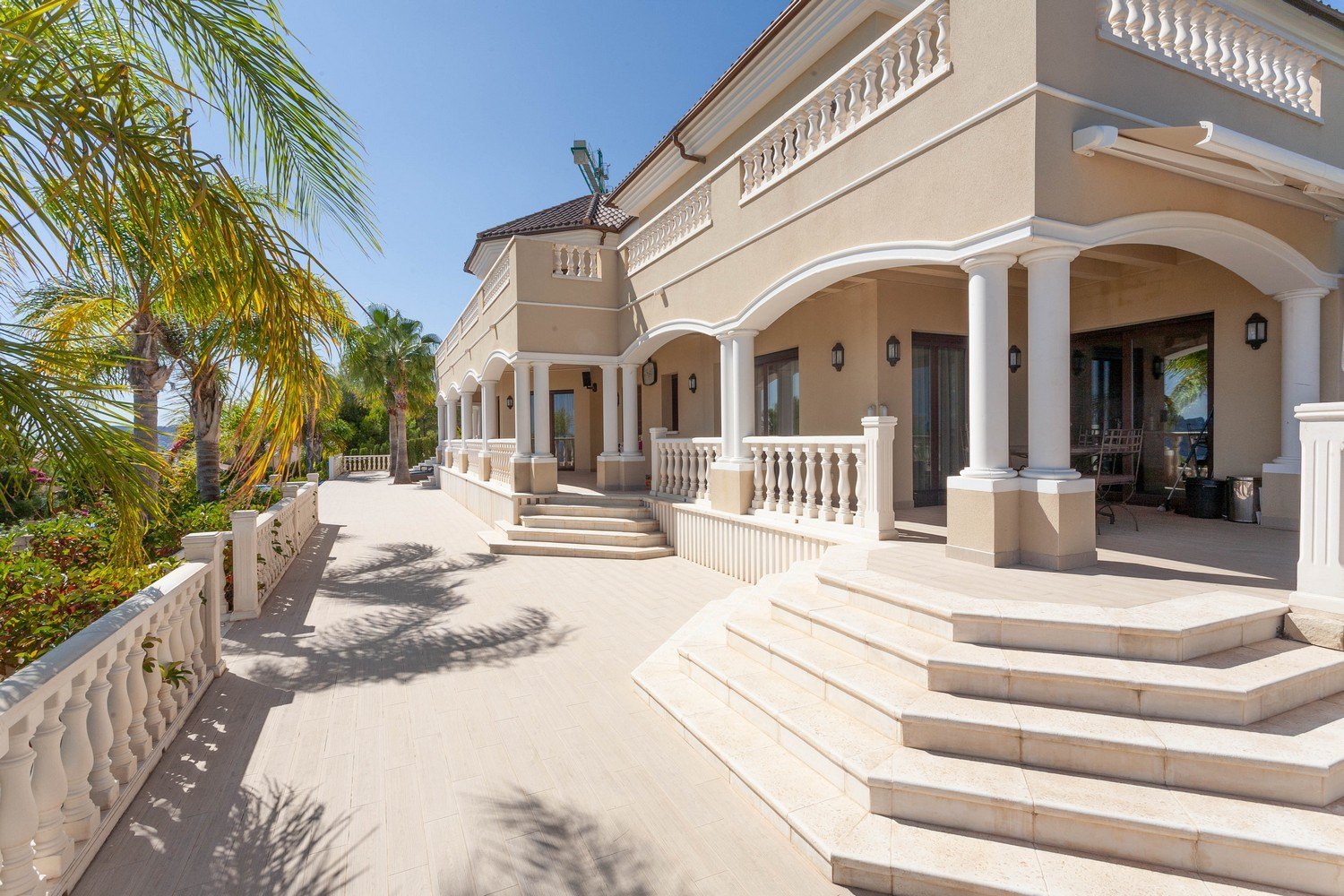 Exterior view of the villa featuring a stone terrace and classic balustrade.
