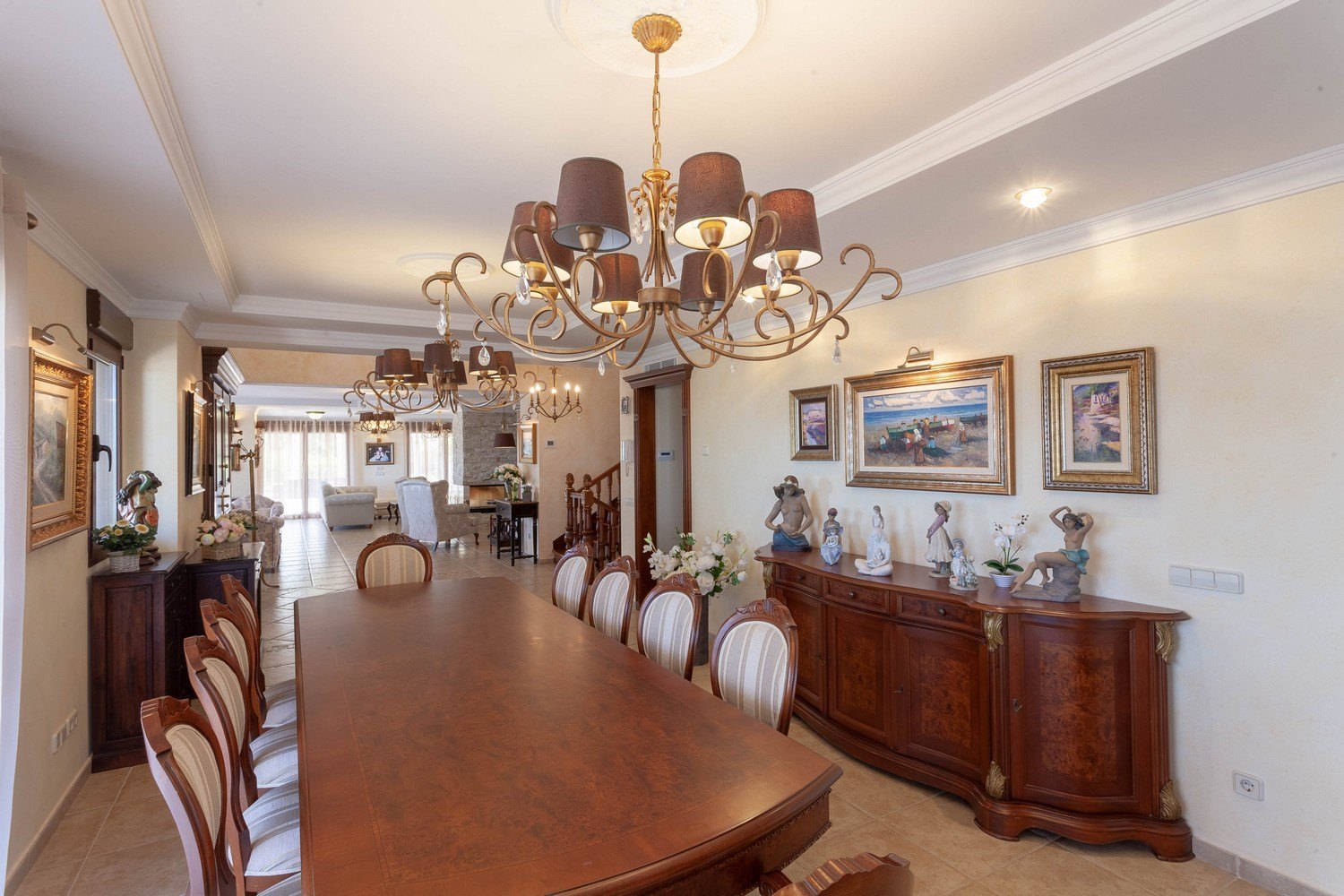Formal dining room featuring a dark wood table, upholstered chairs, and classic sideboard with gold accents.