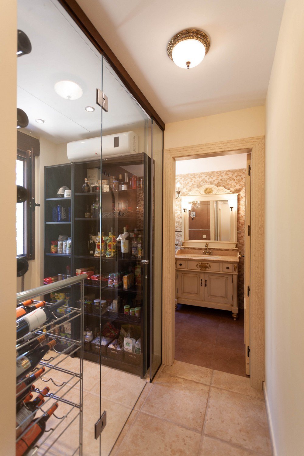 Pantry detail with glass door and bathroom with classic vanity.