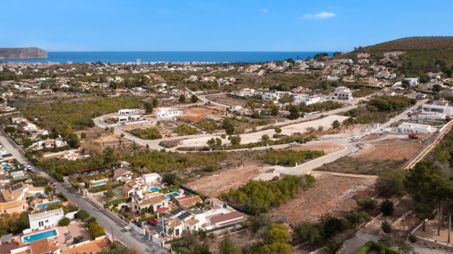 Aerial view of the Lomas Del Rey residential area in Jávea, featuring building plots with panoramic Mediterranean Sea views and surrounding pine forests.