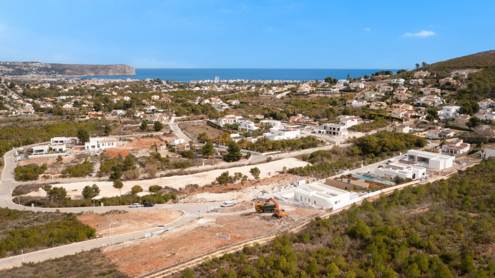 Aerial view of the plot in Lomas Del Rey, Jávea, highlighting the Mediterranean Sea views and the surrounding landscape of pine trees and modern villas.
