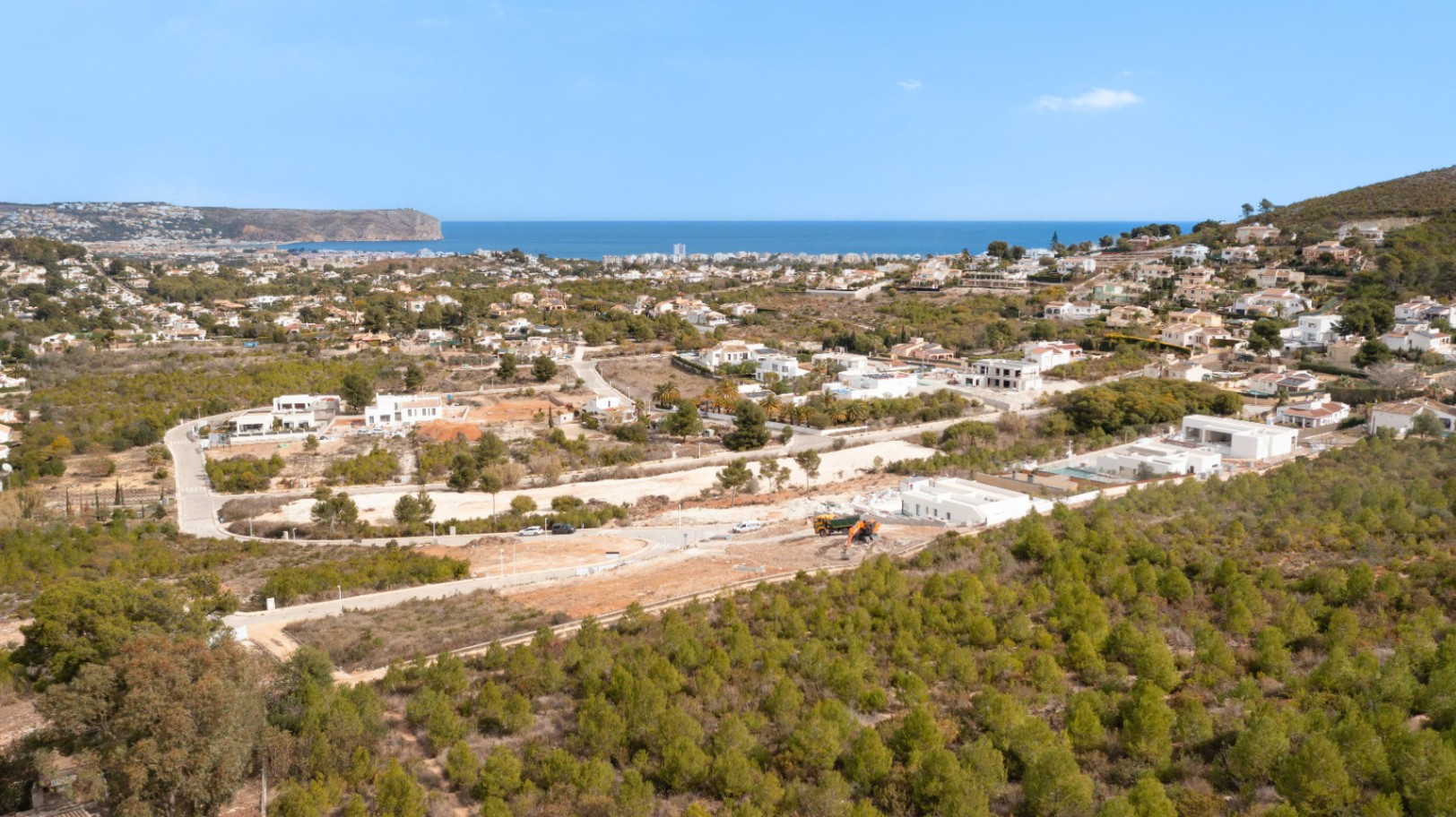 Panoramic aerial view of the plot in Lomas Del Rey, Jávea, highlighting the surrounding pine forest and expansive views of the Mediterranean Sea and coastline.