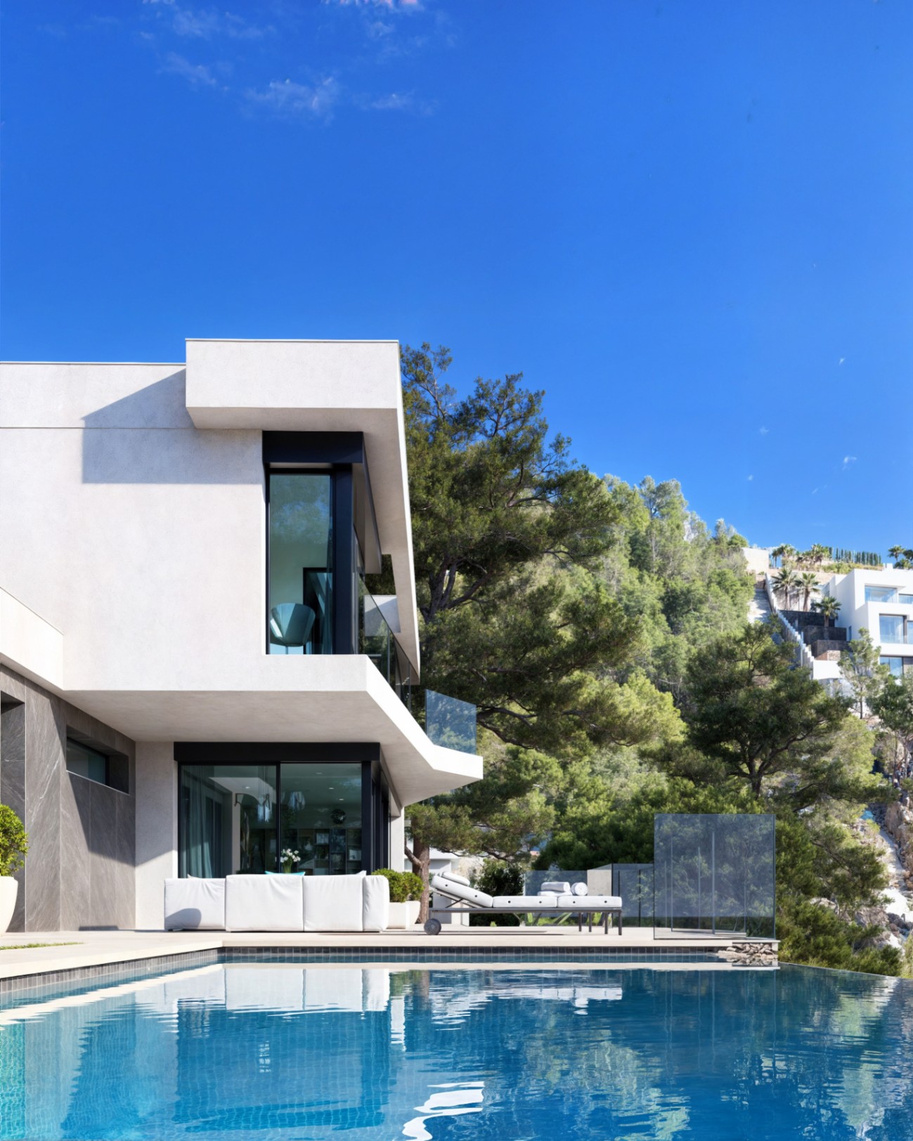 Modern facade featuring an infinity pool, outdoor lounge area, and floor-to-ceiling windows integrated into a lush Mediterranean pine forest.