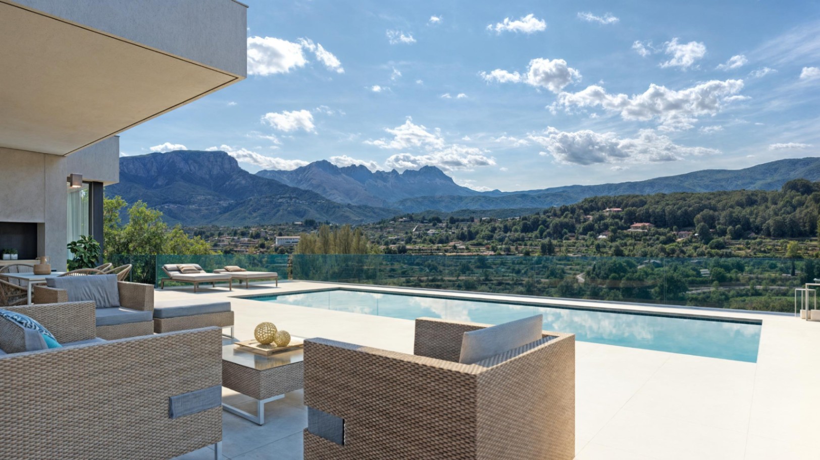 Outdoor terrace with rattan lounge seating and a private pool, featuring glass balustrades and expansive views of the Sierra de Bernia mountains.
