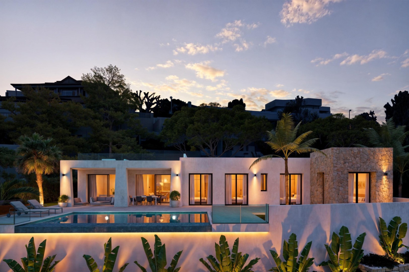 Exterior view of the villa with illuminated pool and stone facade at dusk.