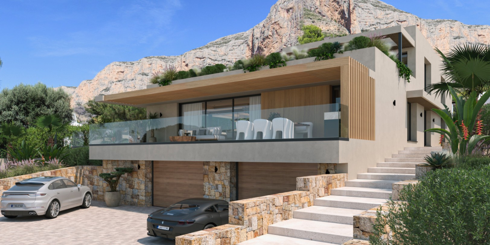 Modern villa exterior featuring natural stone walls, a double garage, and a spacious terrace with glass railings set against the backdrop of the Montgó mountain.