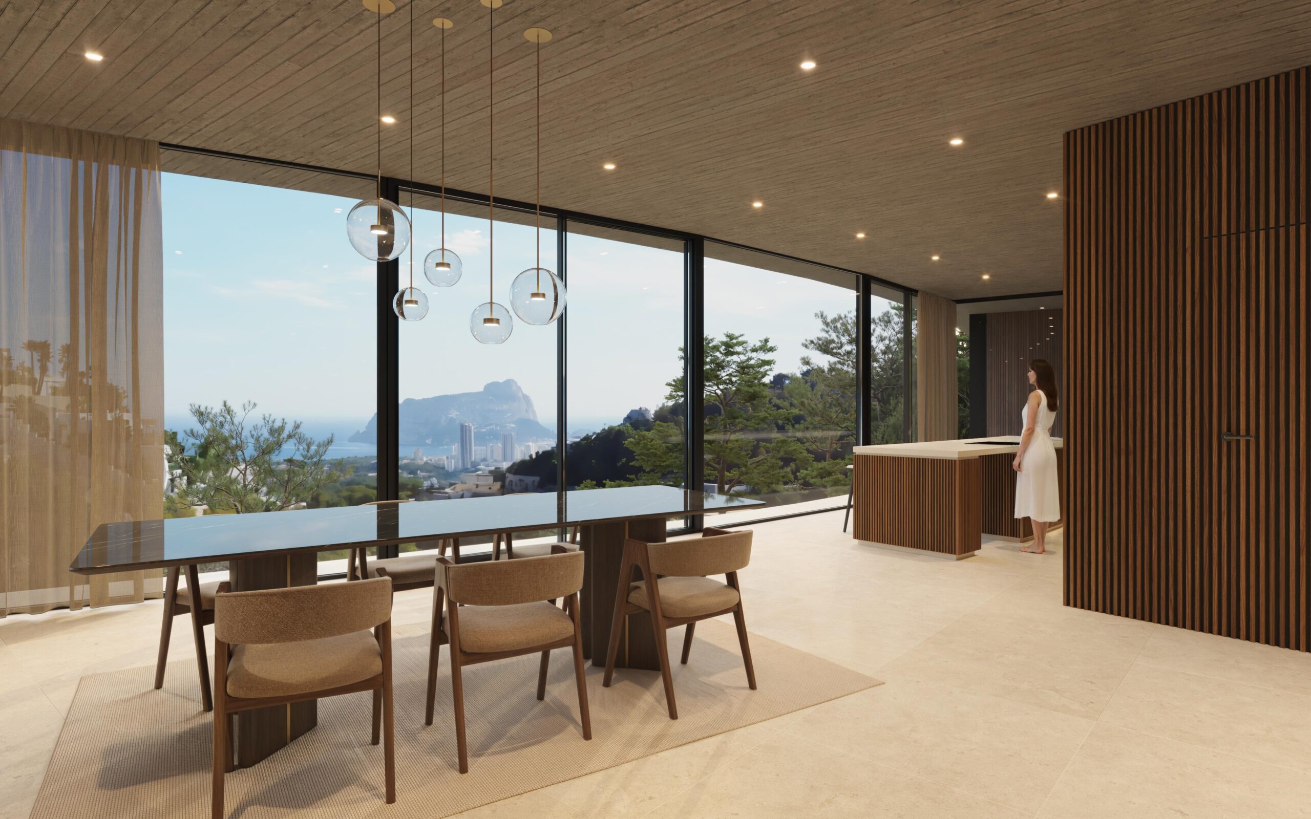 Open-plan dining area with a black marble table, glass pendant lights, and floor-to-ceiling windows overlooking the Peñón de Ifach and the Mediterranean coast.