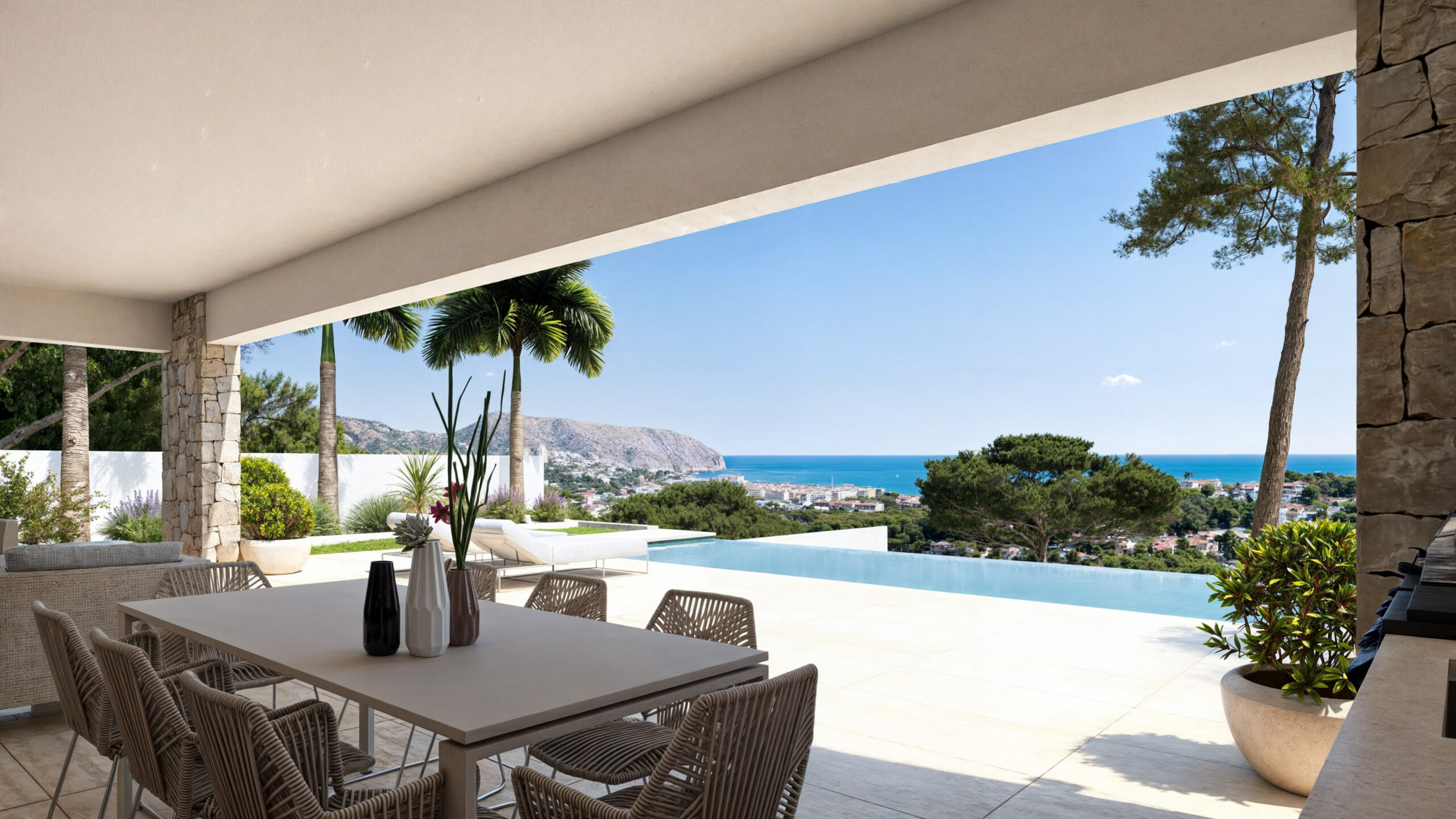 Covered terrace featuring a modern dining set, stone-clad pillars, and an infinity pool overlooking the Mediterranean Sea and coastal mountains.