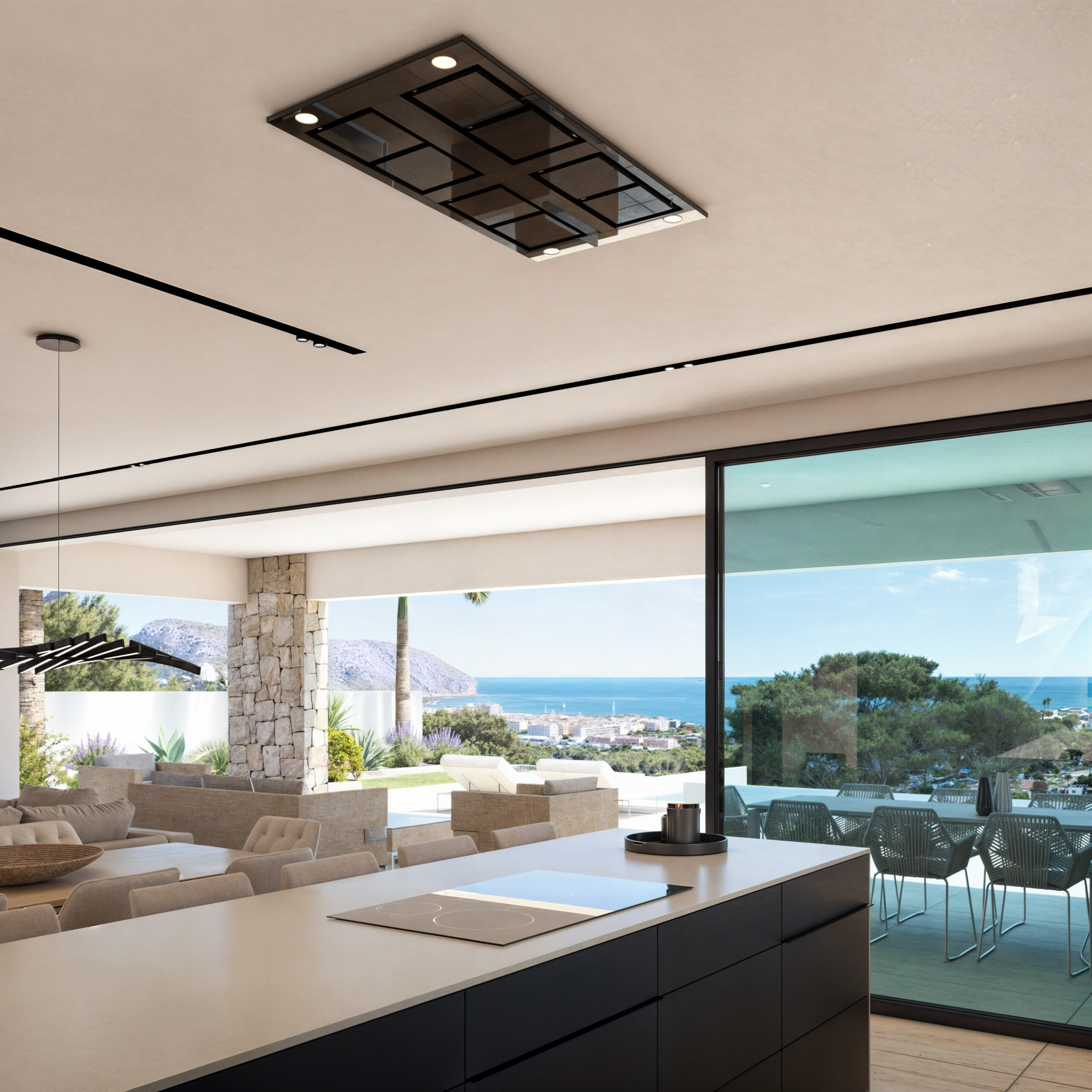 Modern kitchen island with induction cooktop and ceiling extractor, overlooking an open-plan living area and a terrace with panoramic sea views.