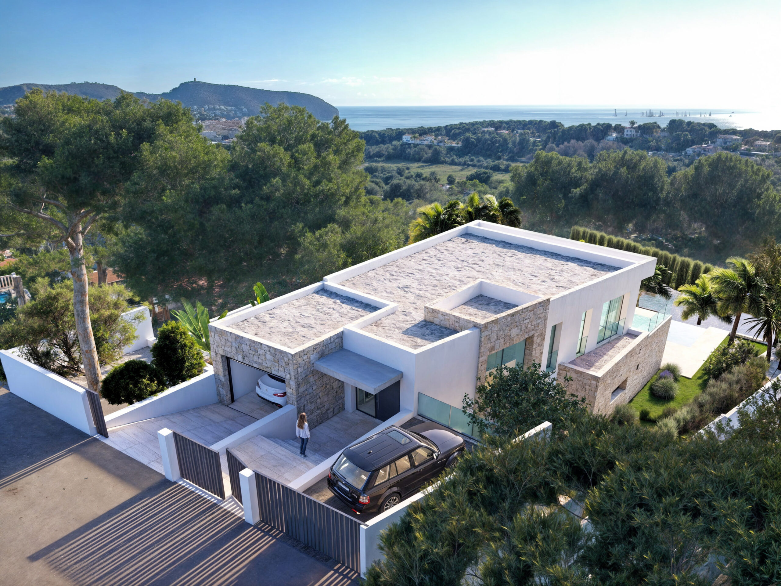 Modern villa exterior featuring natural stone cladding, a gated entrance, and flat roofs with panoramic views of the Mediterranean sea and surrounding greenery.