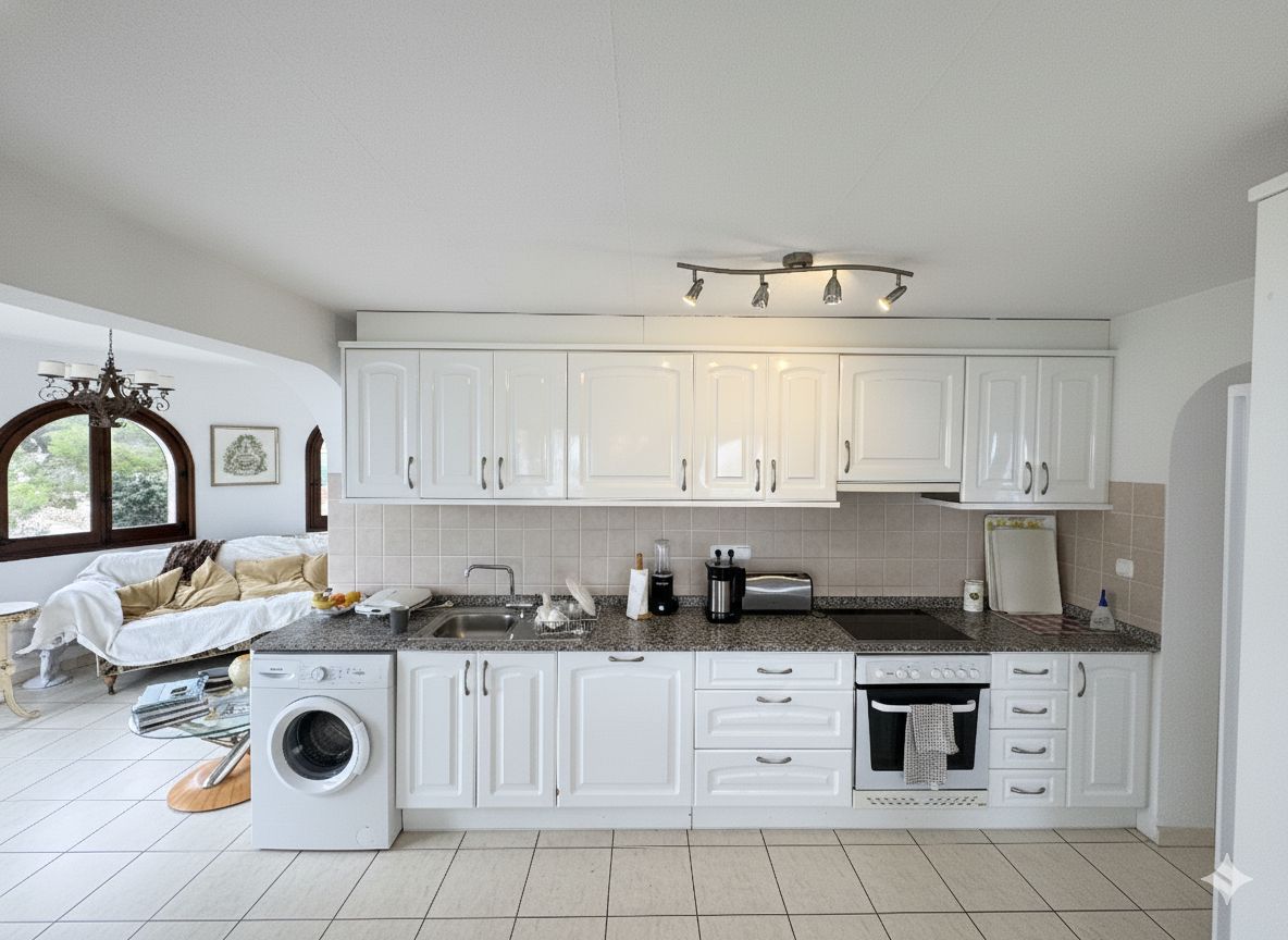 Kitchen with white cabinetry, granite countertops, and integrated appliances including a washing machine and oven. The space features a beige tiled backsplash.