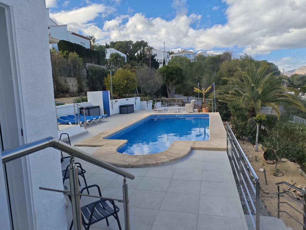 Outdoor swimming pool with Roman steps, featuring a tiled sun terrace, stainless steel railings, and integrated Mediterranean landscaping.