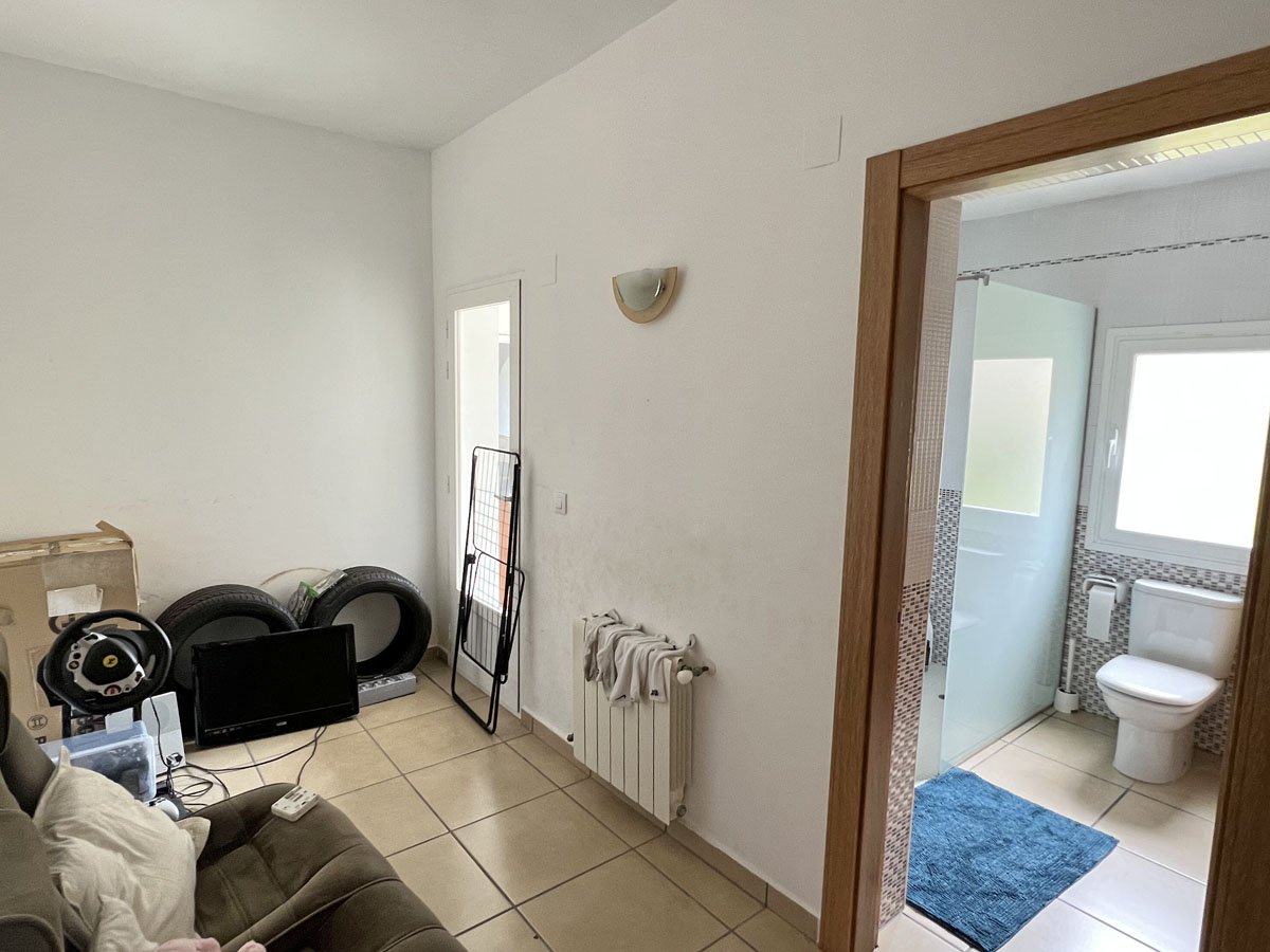 Guest studio featuring an ensuite bathroom, tiled flooring, and central heating. The private bathroom includes a glass shower screen and natural light.