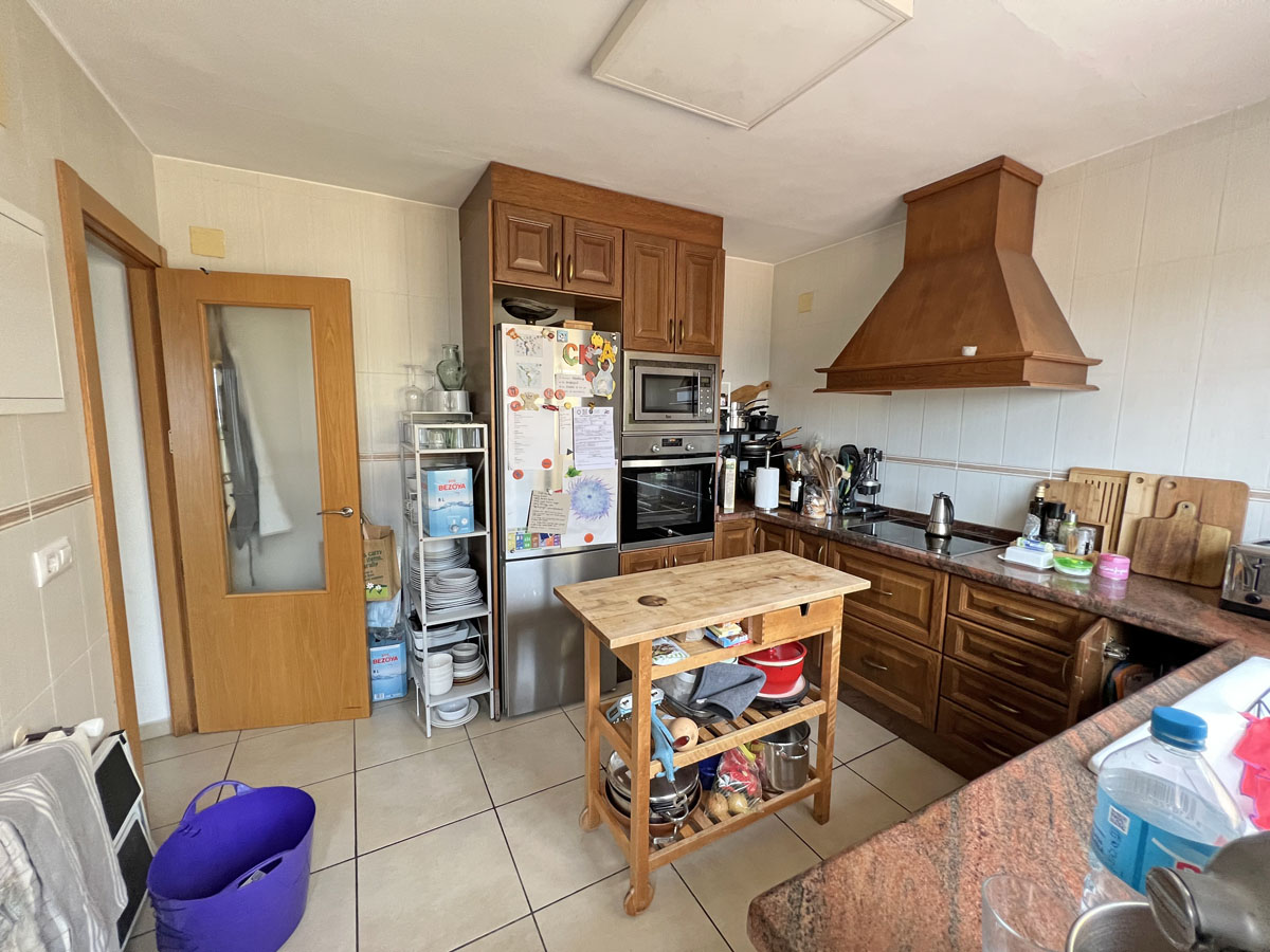 Independent kitchen featuring traditional wood cabinetry, granite countertops, and a mobile butcher block island. Equipped with integrated stainless steel appliances.