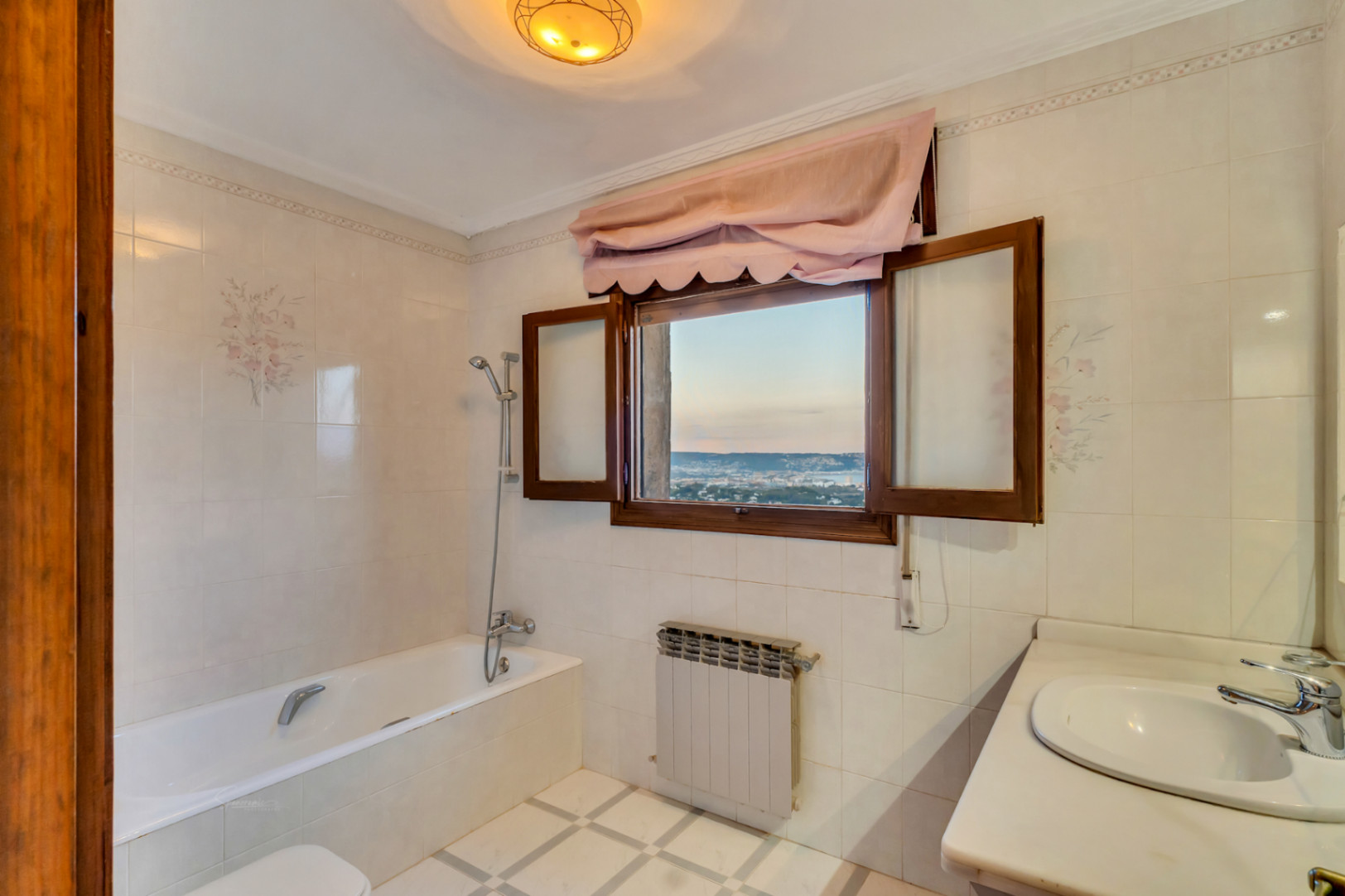 Bathroom featuring a bathtub, marble vanity, and a wooden window frame with panoramic views of the Jávea coastline and bay.