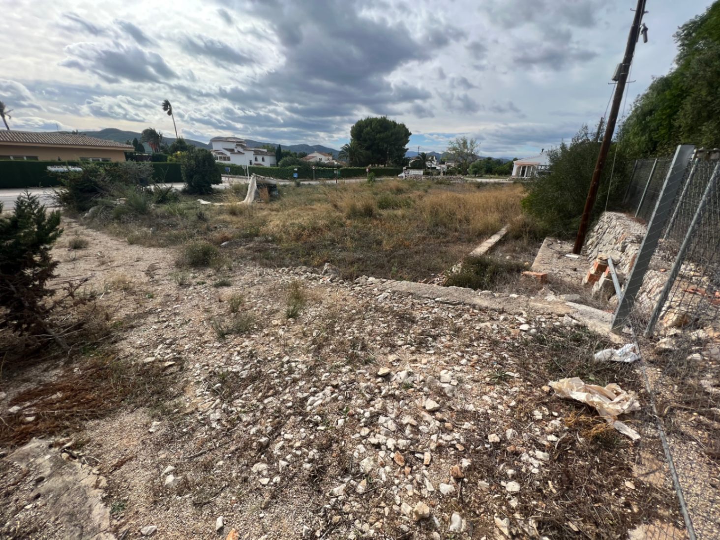 Expansive 2,895sqm plot featuring natural vegetation, stone retaining walls, and clear mountain views, suitable for further construction or landscaping projects.