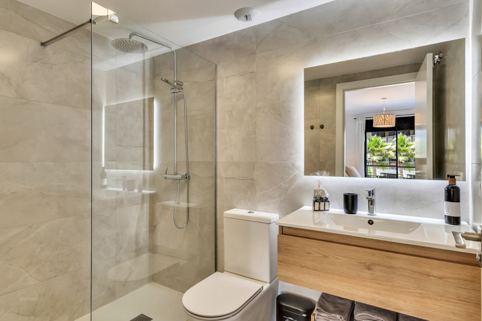 Modern bathroom featuring a walk-in shower with glass partition and rain shower head. Includes a floating wood vanity and a large mirror with integrated LED backlighting.