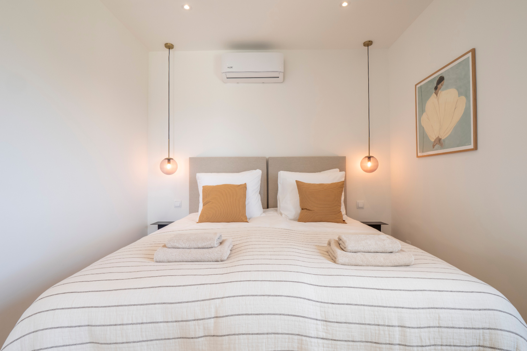 Bedroom featuring a double bed, striped bedding, and spherical pendant lights.