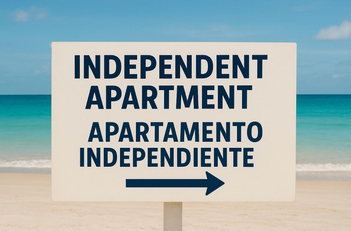 Bilingual sign on the beach indicating the direction of independent apartments.