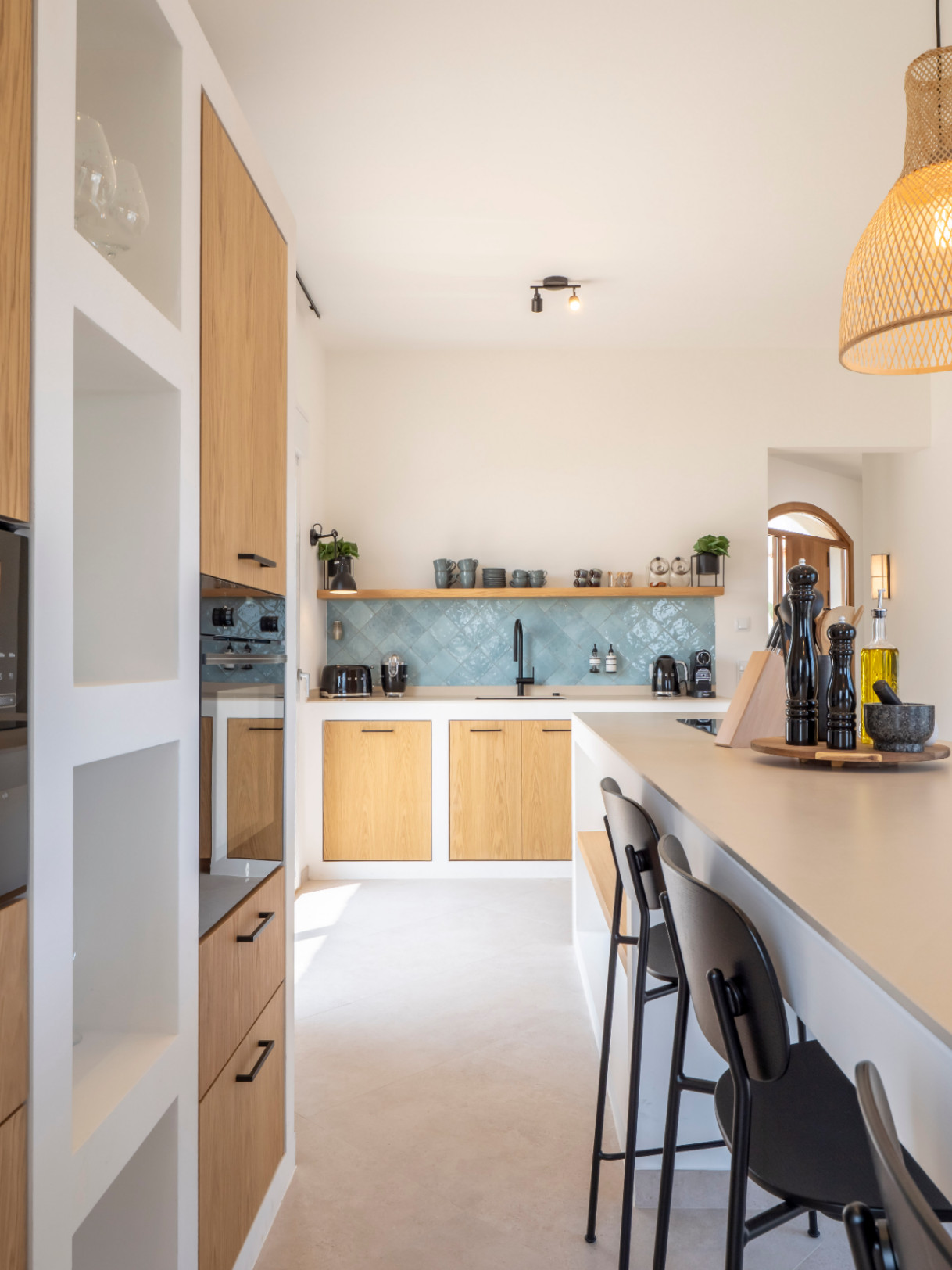 Bright kitchen with a center island, light wood cabinets, and turquoise tile backsplash. Modern and functional design.