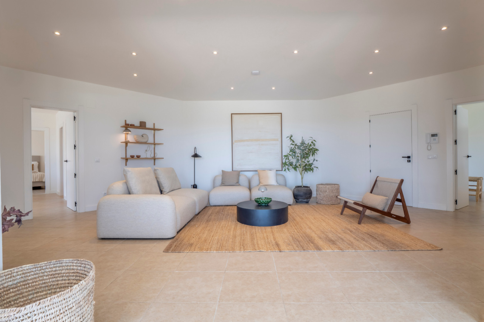 Bright living room with a beige modular sofa, jute rug, and minimalist decor. Recessed lighting throughout.