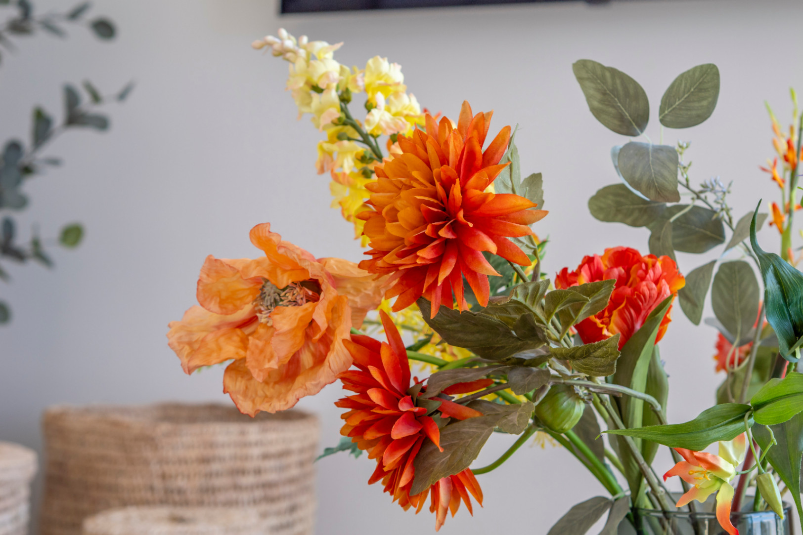 Floral detail with orange dahlia and poppy in a vase, adding a touch of color to the interior.