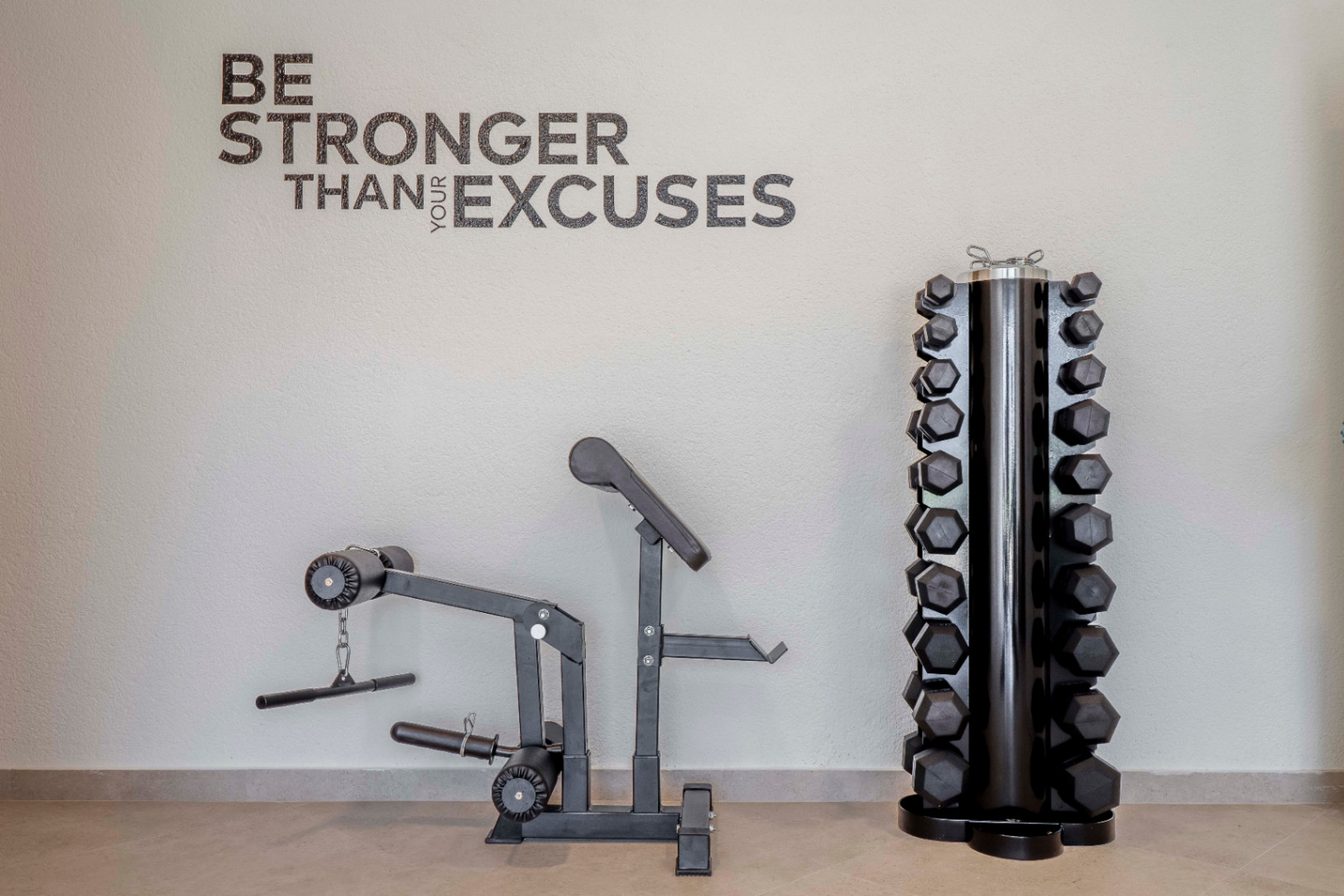 Home gym featuring an exercise machine and a rack of black hexagonal dumbbells.