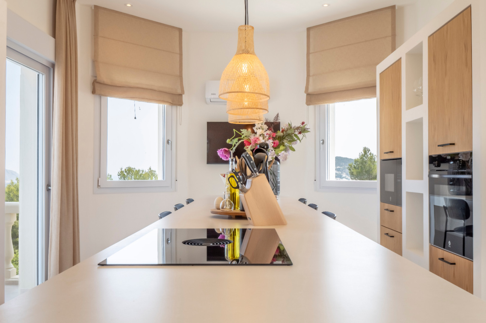 Kitchen detail featuring a central island, induction cooktop, and wicker pendant light.
