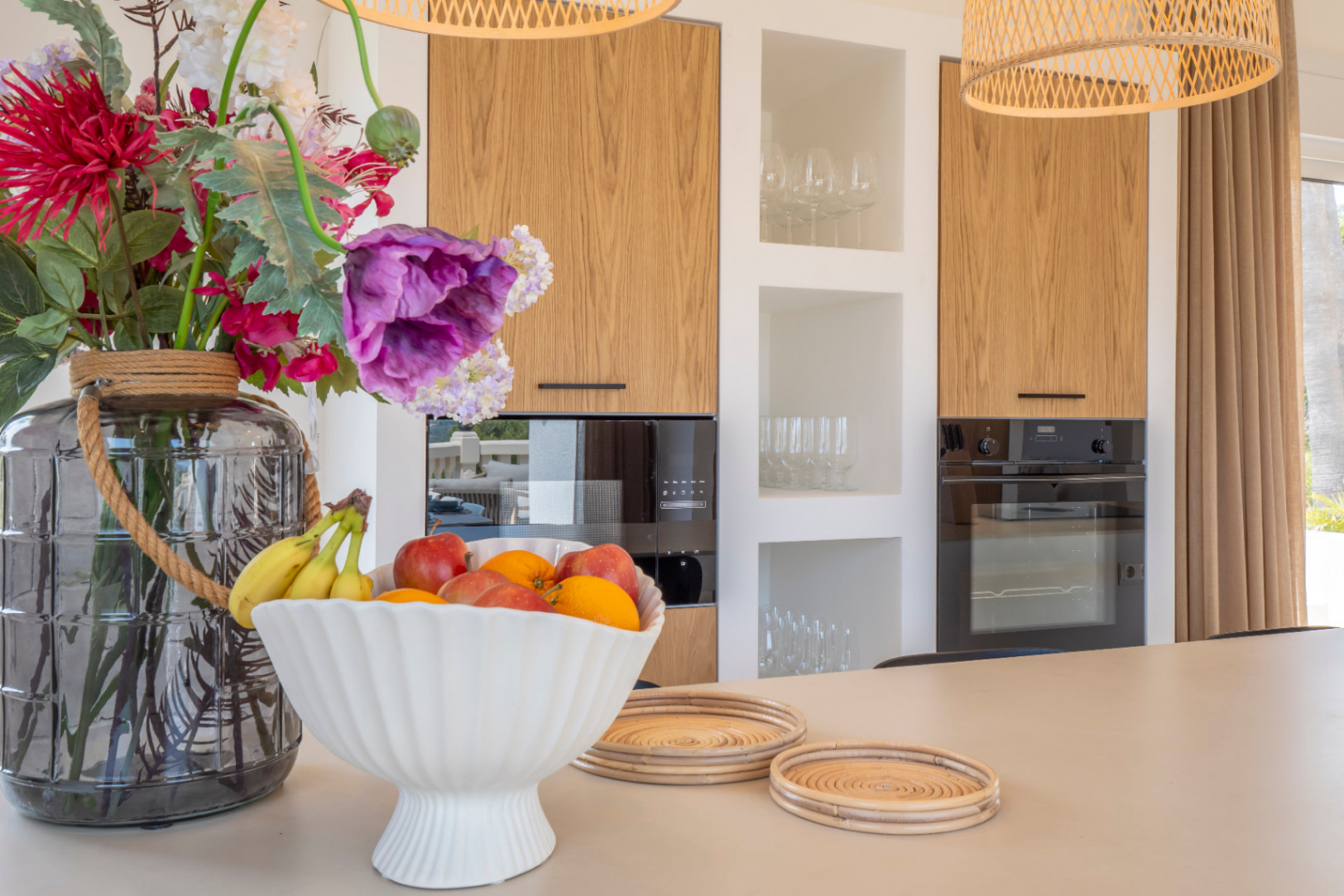 Kitchen detail with island, light wood cabinets, and black appliances.