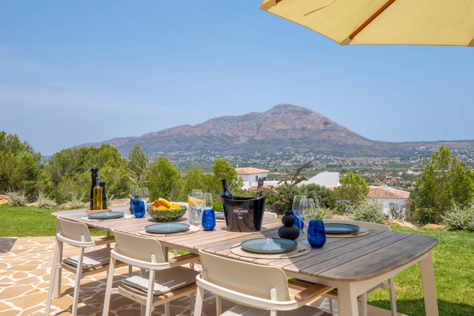 Outdoor dining area with wood table and mountain views in Jávea.