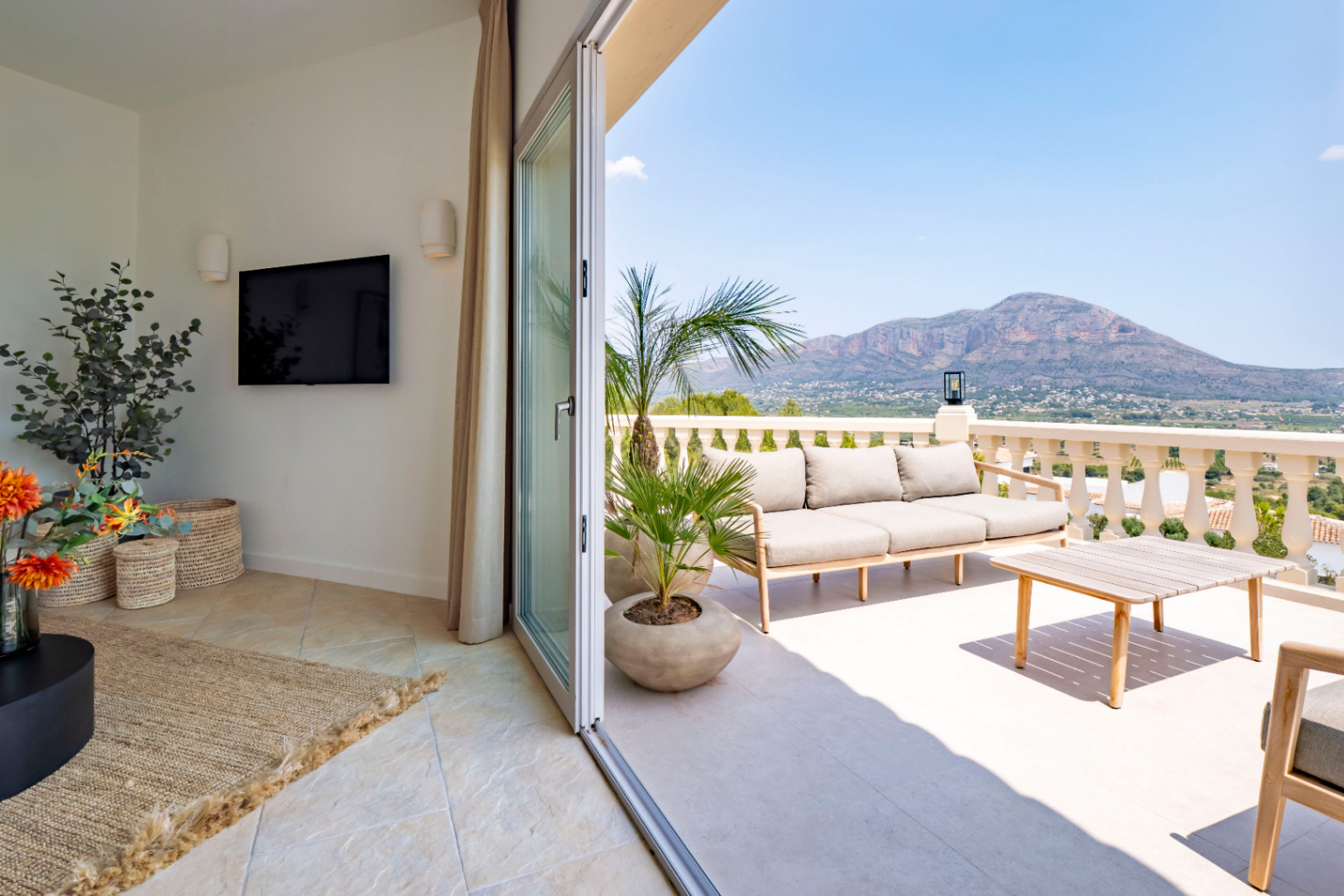 Terrace with mountain views, furnished with a light wood sofa and coffee table.