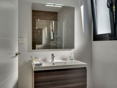 Bathroom detail with modern sink and illuminated mirror.
