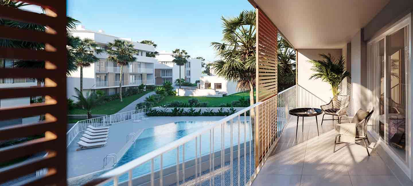 Private terrace with tiled flooring and white railings, overlooking the communal pool and landscaped gardens with palm trees.