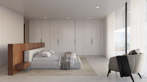Master bedroom featuring a wooden headboard divider, floor-to-ceiling wardrobes, and large windows offering views of the Moraira hills.