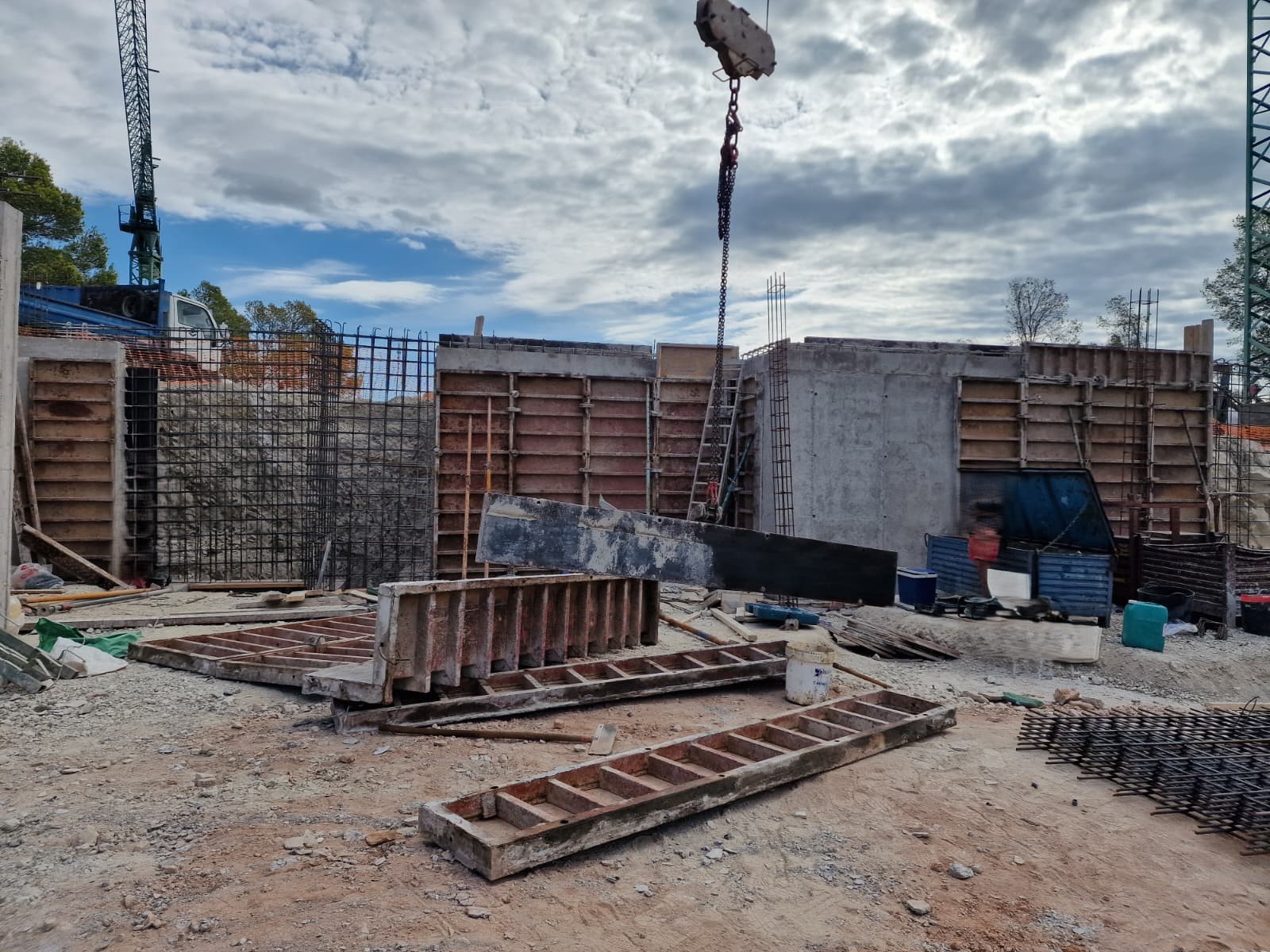 Progress of the structural phase showing reinforced concrete walls, metal formwork, and crane operations on the Moraira villa site.
