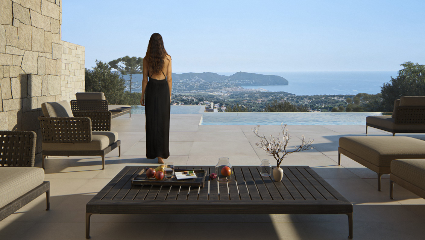 Terrace featuring an infinity pool and panoramic sea views. Includes natural stone cladding, large-format porcelain flooring, and designer outdoor lounge furniture.