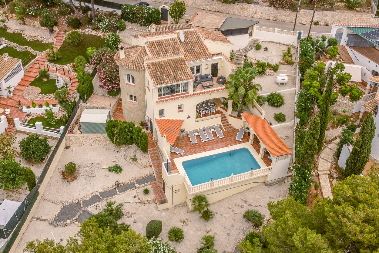 Aerial view of the multi-level villa featuring an 8x4m pool, terracotta terraces, and a stone tower, surrounded by a landscaped Mediterranean garden.
