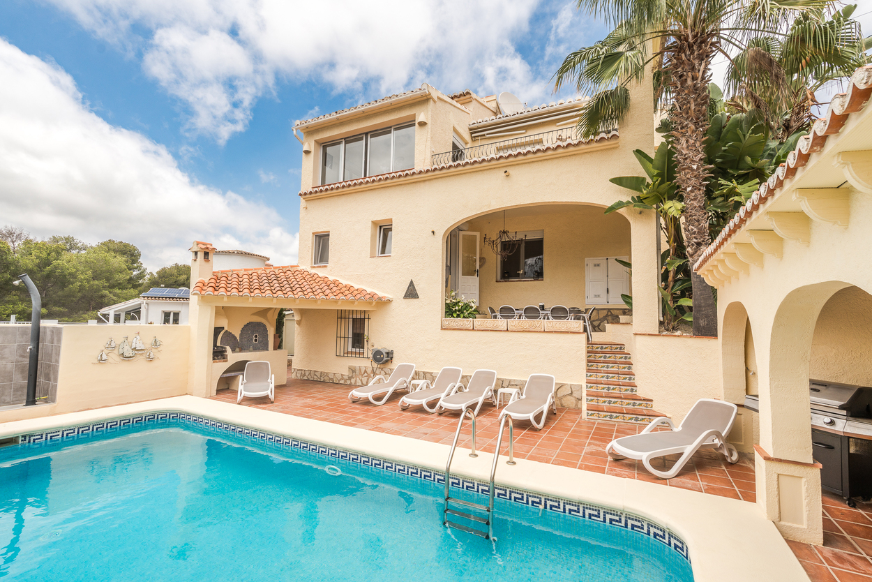 Exterior view of the private 8x4m pool and terracotta terrace, featuring a covered BBQ area, sun loungers, and an arched naya for outdoor dining.