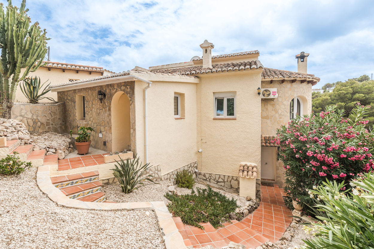 Mediterranean exterior featuring natural stone cladding, terracotta tiled steps with decorative risers, and a low-maintenance garden with native succulents.