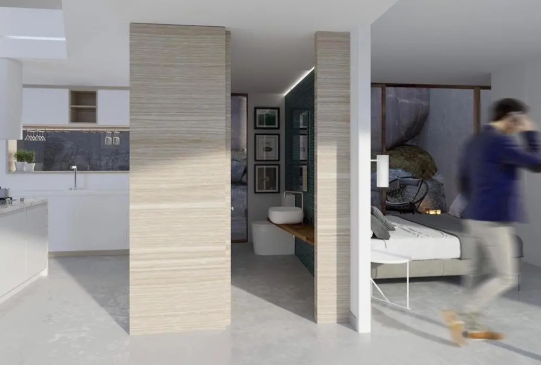 Modern open-plan suite featuring an integrated white kitchen, en-suite bathroom with vessel sink, and bedroom with natural rock views. Light wood partitions define the spaces.