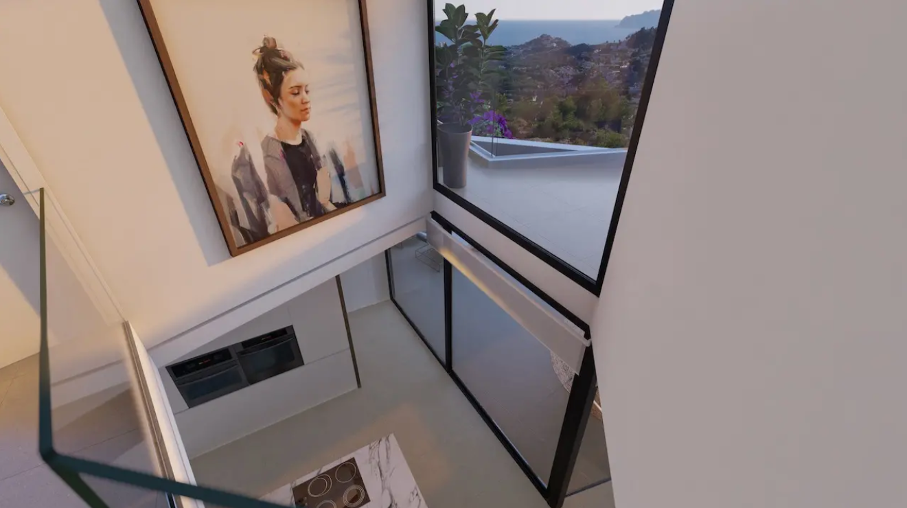 View from the upper level overlooking a double-height kitchen with marble island, integrated appliances, and large windows with panoramic sea views.