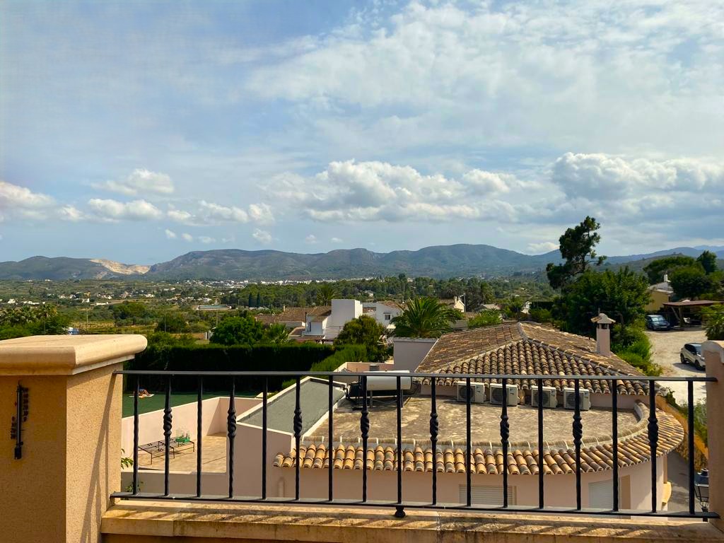 Panoramic views of the Mediterranean countryside and mountains from the terrace, featuring a traditional wrought-iron railing.