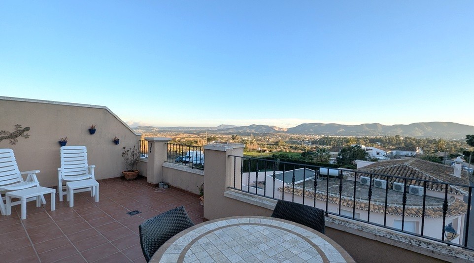 Spacious rooftop terrace featuring terracotta tiling, an outdoor dining area, and panoramic views of the Montgó mountain range and countryside.