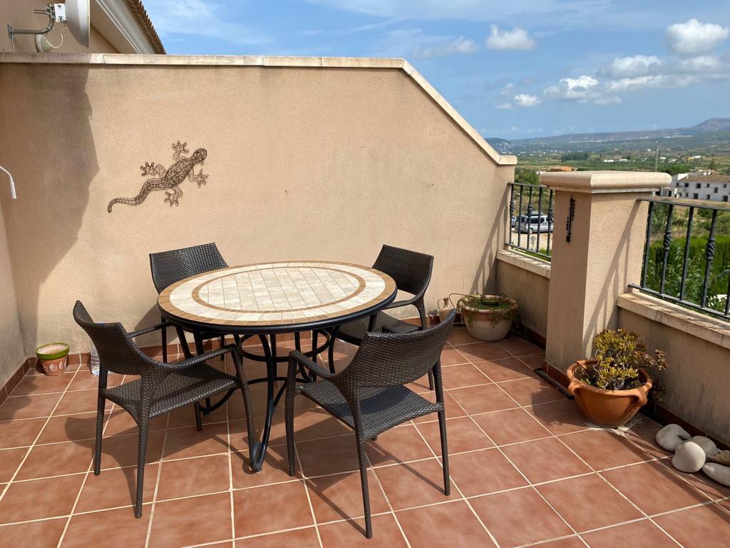Terrace featuring terracotta tiles, a mosaic-topped table with four chairs, and open views overlooking the countryside landscape.