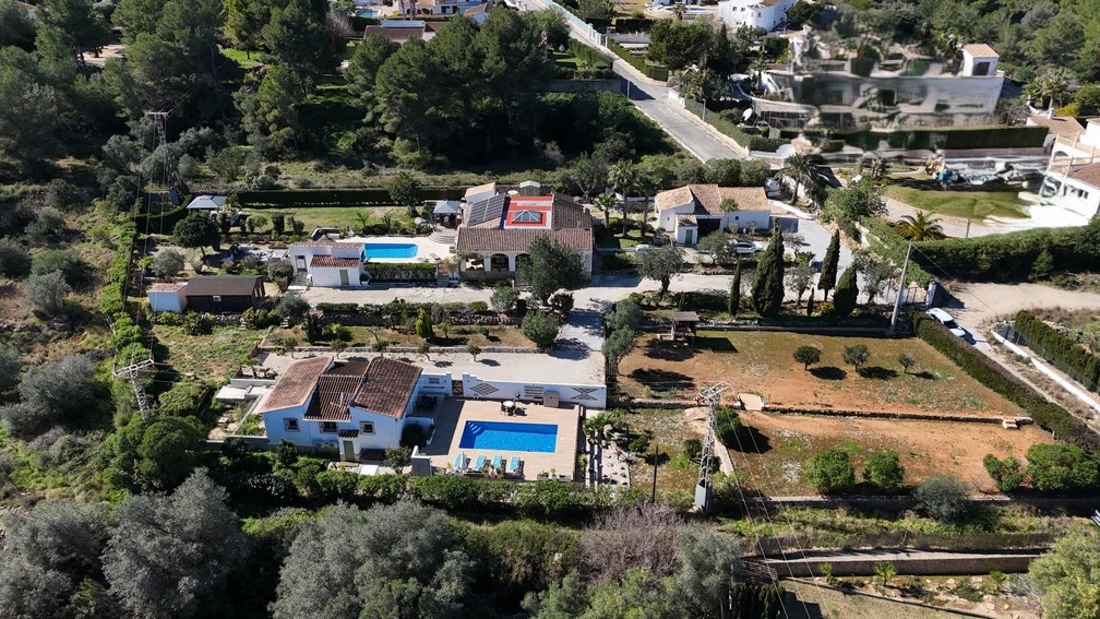 Aerial view of the 4,600 m² plot showing two independent villas with private pools, a wooden cabin, and the main house featuring solar panels and a central glass dome.