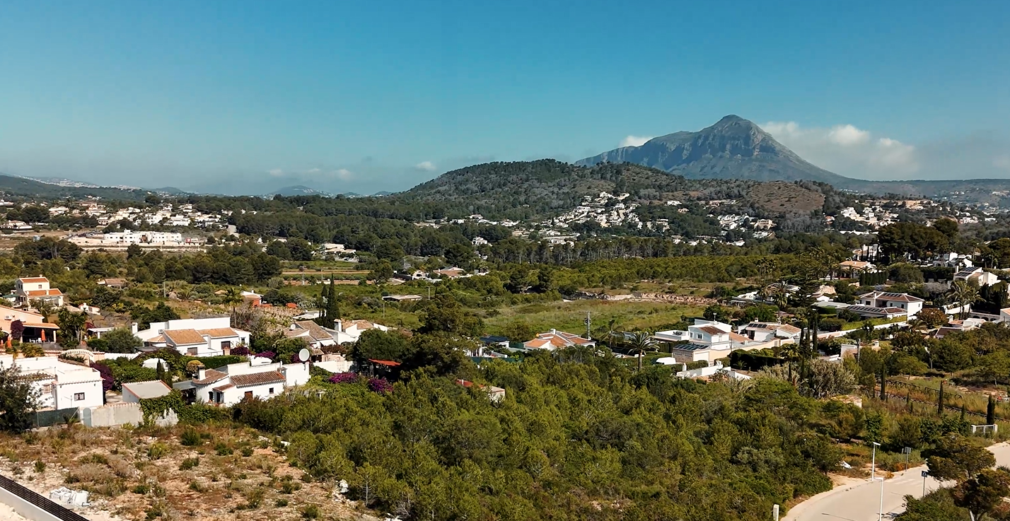 Elevated view of the Lomas del Rey urbanisation in Jávea, featuring the iconic Montgó mountain backdrop and surrounding Mediterranean villas and greenery.