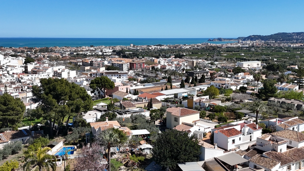 Elevated panoramic view from the terrace overlooking the rooftops of Javea Pueblo, leading to the Mediterranean Sea and the distant coastline.