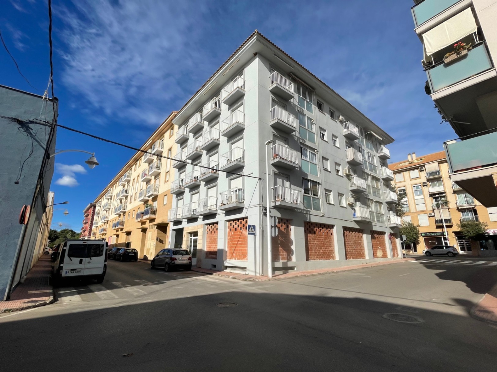 Corner building on Avenida Palmela featuring a ground-floor commercial space. The strategic location offers high visibility and potential for large display windows.